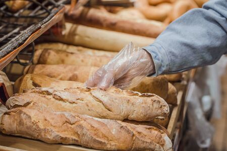 A young woman takes from the counter in the supermarket fresh bread . Health food. Healthy food, organic products.の写真素材