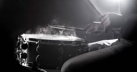 man playing the snare drum on a beautiful colored background, the concept of musical instrumentsの写真素材