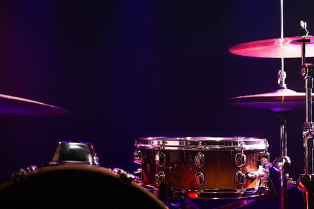 Drums and drum set. Beautiful blue and red background, with rays of light. Beautiful special effects of smoke and lighting. Musical instrument. The concept of music. Close-up photo.の写真素材