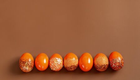 Beautiful Easter background with orange decorative eggs in spangles . The concept of the Easter holiday.の写真素材