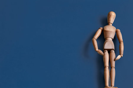 The wooden man figurine on a blue background . Concept of objects .の写真素材
