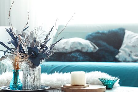Modern living room, with artificial flowers in a vase and home decor items on a wooden light table.の写真素材