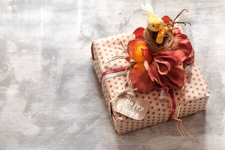 Beautiful Easter gift on a white wooden background. The concept of Easter decorations and celebration.の写真素材