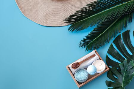 Spa. Body care items on a blue background with tropical leaves. Summer accessories. Poster banner, postcard template. Space for text.の写真素材