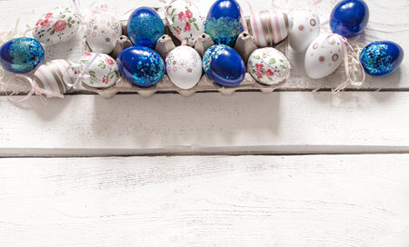 Stylish beautiful composition with blue Easter eggs on a white wooden background. The concept of...