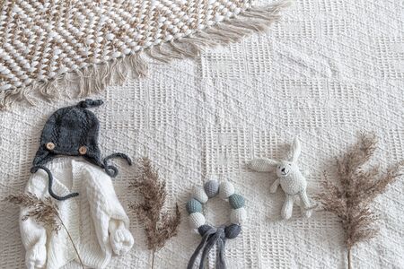 Set of children's stylish handmade knitted clothes with various accessories in the boho style, top view.の写真素材