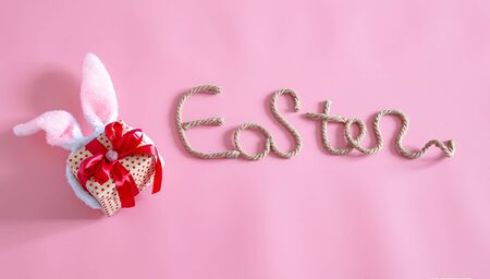 Spring Easter festive background. Creative inscription on a pink background with items decor.の写真素材