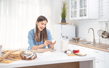 A young beautiful woman prepares homemade cakes in the kitchen . The concept of proper healthy home...