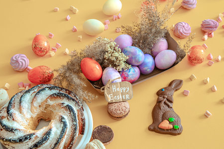 Easter composition with eggs and cupcake on a colored background. The concept of the Easter...