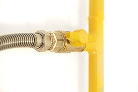 Yellow gas pipe with a valve. White background. Space for text.の写真素材