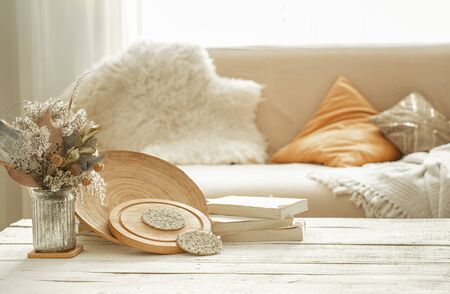Decorative items in the cozy interior of the room , a vase with dried flowers on a light wooden table.の写真素材