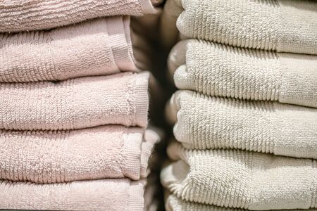 Home textiles beautiful towels are stacked on a shelf in the store. Close up.の写真素材