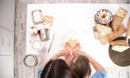 The view from the top. Mom and daughter prepare pastries in the kitchen. The concept of a loving...