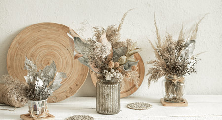 Background composition with many different dried flowers in vases, on a light background.