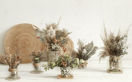 Background composition with many different dried flowers in vases, on a light background.の写真素材
