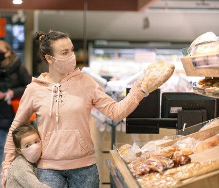 A young woman shopping in a supermarket during a virus epidemic. Wears a mask on his face.