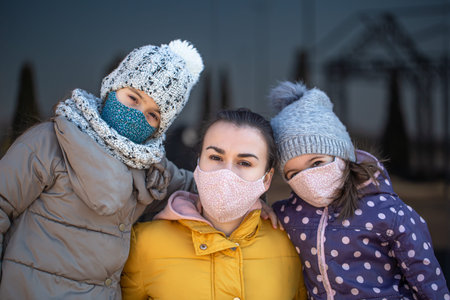 A mother with two children in masks during the pandemic. Coronavirus