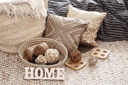 Items of a cozy home interior with pillows and a wooden sign home .Coziness and comfort at home .の写真素材