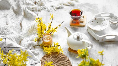 Spring still life with a Cup of tea and flowers . Light background, blooming and cozy house.の写真素材