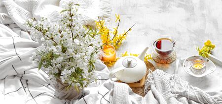 Spring still life with a Cup of tea and flowers . Light background, blooming and cozy house.の写真素材