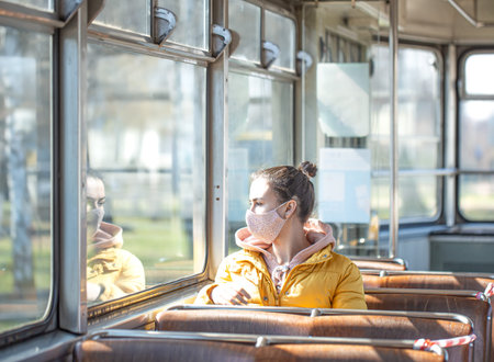 A young woman in an empty public transport during the pandemic. Coronavirus.