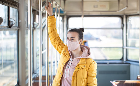 A young woman in an empty public transport during the pandemic. Coronavirus.の写真素材