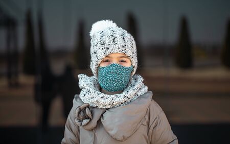 Coronavirus concept .A little girl wears a mask on her face during a virus epidemicの写真素材