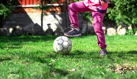 Children play football on the grass, keep their foot on the ball. The concept of a team game.