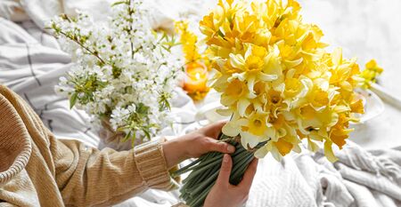 A young woman holds a bouquet of daffodils.The concept of spring and flowering.の写真素材