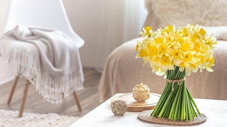 Composition with spring flowers in a cozy living room interior . The concept of decor and comfort.の写真素材