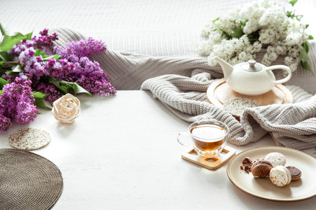 Cozy spring composition with tea and blooming lilac. Top view, flat lay