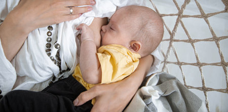 Baby eating breast milk. Mother breastfeeding her baby boy. Concept of lactation close up.