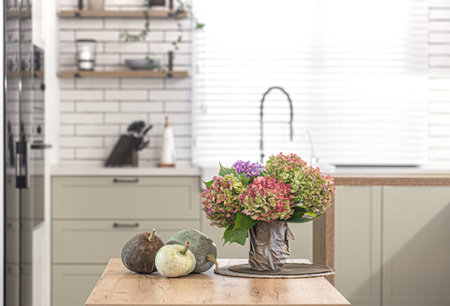 Autumn composition of flowers of hydrangeas and pumpkins on the background of the interior of a...