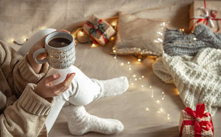 A woman is holding a beautiful cup with a hot drink. Cozy winter concept.の写真素材