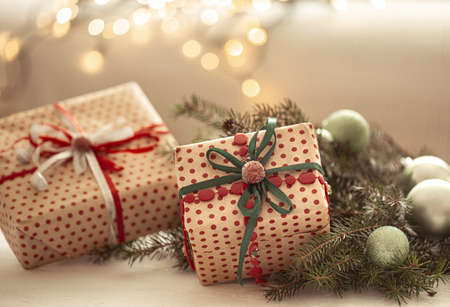 Close up shot of beautifully wrapped christmas gifts on blurred background of blurry lights.の写真素材