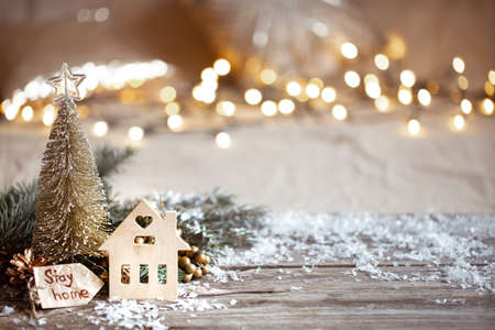 Winter cozy background with festive decor details, snow on a wooden table and bokeh. Stay home concept.