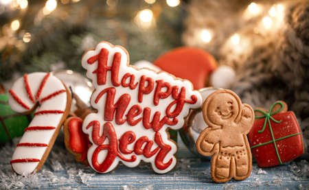 Composition with bright Christmas glazed gingerbread cookies on a blurred background with bokeh. Craft homework cookies for Christmas.の写真素材