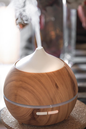 Aroma oil diffuser lamp on a table. Aromatherapy and health care concept.
