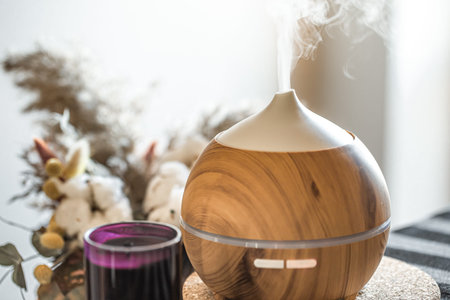 Aroma oil diffuser lamp on a table. Aromatherapy and health care concept.