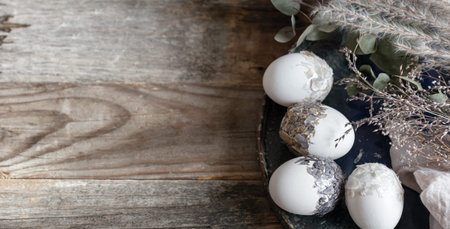Easter eggs with dried flowers on a wooden table. Happy Easter concept.