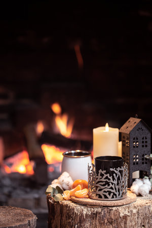 Still life with hot drinks, candle and decor against the background of a burning fire. The concept of a village holiday outside the city.の写真素材