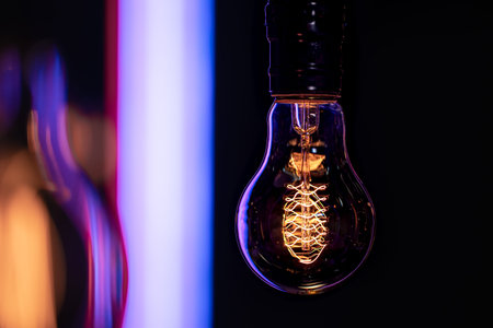 A burning lamp hangs in the dark on a blurred background. The concept of decor and atmosphere.