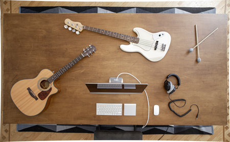 Top view of a composition of musical instruments on a wooden table in a recording studio. Musician's workplace for creativity.の写真素材