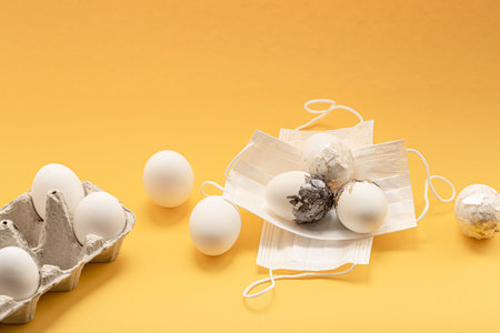 Minimally decorated Easter eggs are masked against the coronavirus. Easter safe celebration concept.