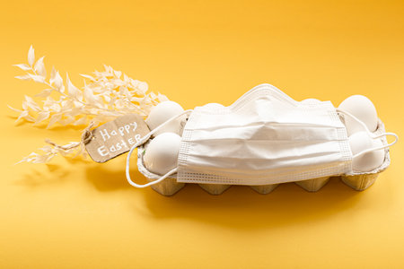 Chicken egg tray and protective medical mask. Happy easter concept during coronavirus pandemic.の写真素材