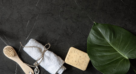 Still life with body brush, towel and soap on a dark marble surface copy space. Body care concept.の写真素材
