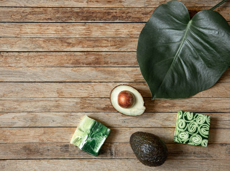 Still life with handmade soap, natural leaf and avocado top view. Organic cosmetics and beauty concept.の写真素材