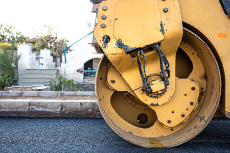 Road roller makes the paving. Road roller compacting asphalt. Roller Compactor on Fresh Asphalt.