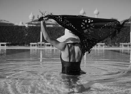 A girl in the pool on a hot sunny day. Concept of vacation and resort in a warm country.の写真素材