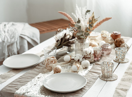 Empty plates and glasses on a decorated dining table for the Easter holiday. Beautiful hygge-style...
